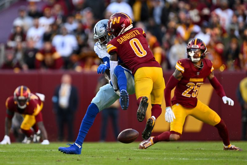 Washington Commanders cornerback Mike Sainristil (0) breaks up a pass intended for Dallas Cowboys wide receiver Jalen Brooks during the second half of an NFL football game, Sunday, Nov. 24, 2024, in Landover, Md. (AP Photo/Terrance Williams)