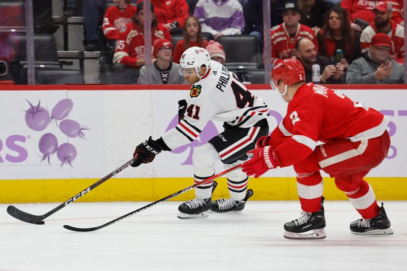 Nov 30, 2023; Detroit, Michigan, USA; Chicago Blackhawks defenseman Isaak Phillips (41) skates with the puck defended by Detroit Red Wings defenseman Olli Maatta (2) in the third period at Little Caesars Arena. Mandatory Credit: Rick Osentoski-USA TODAY Sports