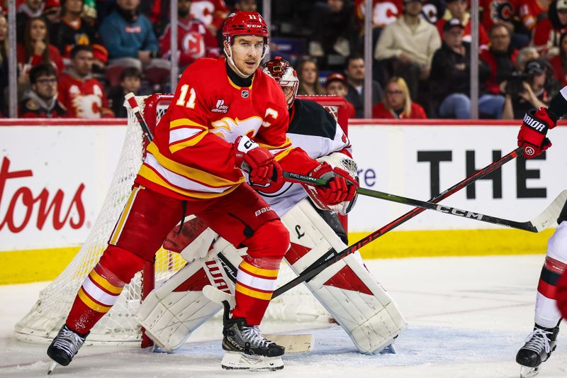 Jan 19, 2026; Calgary, Alberta, CAN; Calgary Flames center Mikael Backlund (11) screens in front of New Jersey Devils goaltender Jacob Markstrom (25) during the second period at Scotiabank Saddledome. Mandatory Credit: Sergei Belski-Imagn Images
