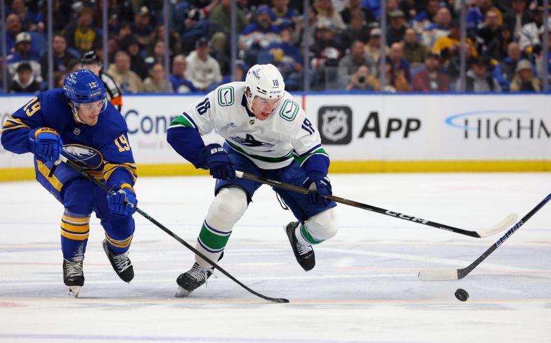 Jan 6, 2026; Buffalo, New York, USA;  Buffalo Sabres center Peyton Krebs (19) and Vancouver Canucks left wing Drew O'Connor (18) go after a loose puck during the first period at KeyBank Center. Mandatory Credit: Timothy T. Ludwig-Imagn Images