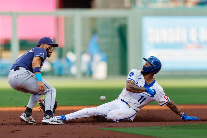 Jun 25, 2025; Kansas City, Missouri, USA; Kansas City Royals third base Maikel Garcia (11) slides into second base under a throw to Tampa Bay Rays shortstop José Caballero (77) during the first inning at Kauffman Stadium. Mandatory Credit: William Purnell-Imagn Images