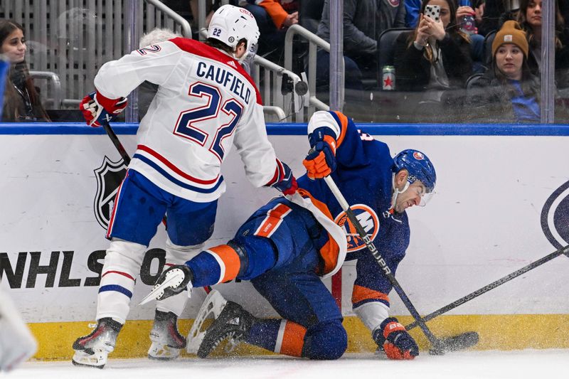 Apr 11, 2024; Elmont, New York, USA; New York Islanders defenseman Adam Pelech (3) and Montreal Canadiens right wing Cole Caufield (22) battle for the puck along the boards during the first period at UBS Arena. Mandatory Credit: Dennis Schneidler-USA TODAY Sports