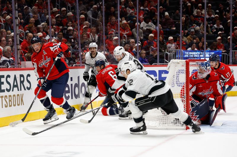 Nov 17, 2025; Washington, District of Columbia, USA; Washington Capitals defenseman John Carlson (74) skates with the puck behind Capitals goaltender Charlie Lindgren (79) as Los Angeles Kings left wing Trevor Moore (12) chases during the second period at Capital One Arena. Mandatory Credit: Geoff Burke-Imagn Images