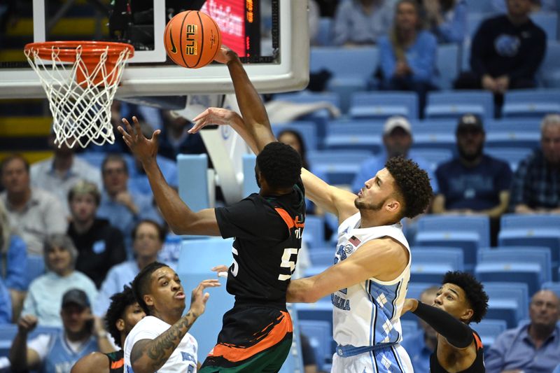 Feb 13, 2023; Chapel Hill, North Carolina, USA; Miami (Fl) Hurricanes guard Wooga Poplar (55) and North Carolina Tar Heels forward Pete Nance (32) fight for a rebound in the first half at Dean E. Smith Center. Mandatory Credit: Bob Donnan-USA TODAY Sports