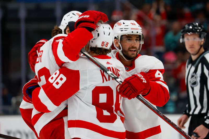 Feb 19, 2024; Seattle, Washington, USA; Detroit Red Wings defenseman Moritz Seider (53, left) celebrates with right wing Patrick Kane (88) and defenseman Shayne Gostisbehere (41) after scoring a goal against the Seattle Kraken during the first period at Climate Pledge Arena. Mandatory Credit: Joe Nicholson-USA TODAY Sports