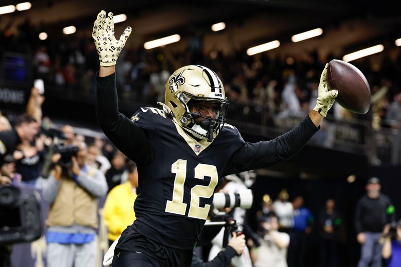 New Orleans Saints wide receiver Chris Olave (12) celebrates a touchdown against Atlanta Falcons cornerback Clark Phillips III (34) in the second half of an NFL football game in New Orleans, Sunday, Jan. 7, 2024. (AP Photo/Butch Dill)