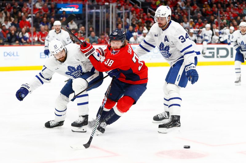 Mar 20, 2024; Washington, District of Columbia, USA; Washington Capitals defenseman Rasmus Sandin (38) battles for the puck between Toronto Maple Leafs defenseman Timothy Liljegren (37) and Maple Leafs center Auston Matthews (34) during the third period at Capital One Arena. Mandatory Credit: Amber Searls-USA TODAY Sports