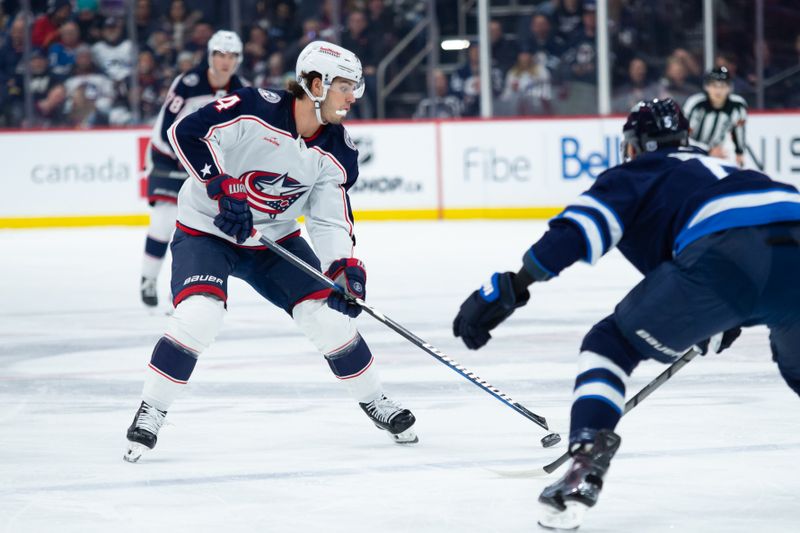 Jan 9, 2024; Winnipeg, Manitoba, CAN; Columbus Blue Jackets forward Cole Sillinger(4) skates in on Winnipeg Jets defenseman Brenden Dillon (5) during the first period at Canada Life Centre. Mandatory Credit: Terrence Lee-USA TODAY Sports