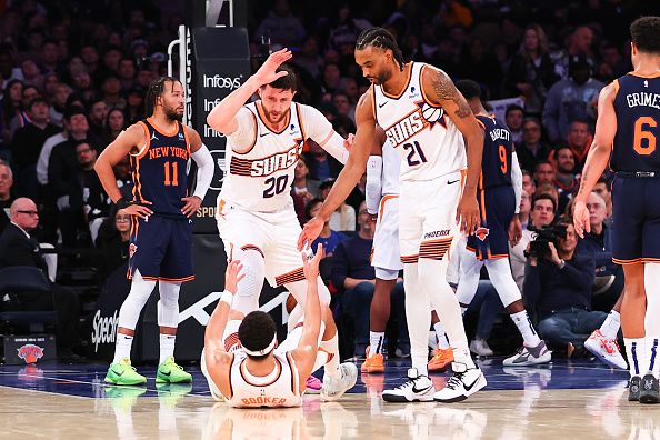 NEW YORK, NY - NOVEMBER 26:  Devin Booker #1 of the Phoenix Suns is helped up by Jusuf Nurkic #20 and Keita Bates-Diop #21 during the game against the New York Knicks at Madison Square Garden on November 26, 2023 in New York City.  NOTE TO USER: User expressly acknowledges and agrees that, by downloading and or using this photograph, User is consenting to the terms and conditions of the Getty Images License Agreement. (Photo by Rich Graessle/Getty Images)