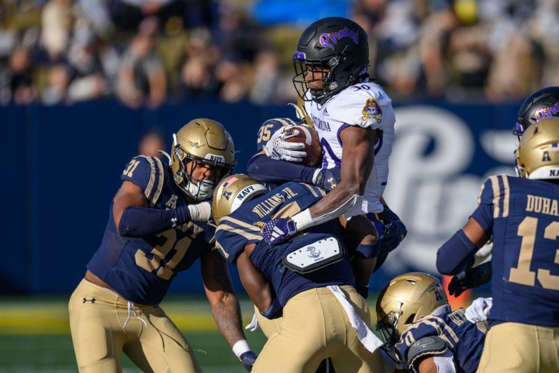 Nov 18, 2023; Annapolis, Maryland, USA; East Carolina Pirates running back Javious Bond (30) is tackled by Navy Midshipmen safety Xavier McDonald (31) and defensive end Mbiti Williams Jr. (7) during the third quarter at Navy-Marine Corps Memorial Stadium. Mandatory Credit: Reggie Hildred-USA TODAY Sports