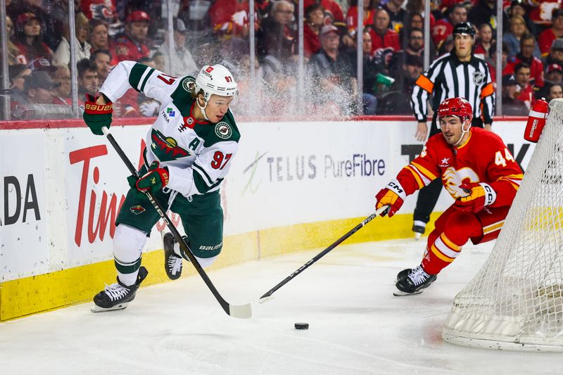 Apr 11, 2025; Calgary, Alberta, CAN; Minnesota Wild left wing Kirill Kaprizov (97) controls the puck against Calgary Flames defenseman Joel Hanley (44) during the first period at Scotiabank Saddledome. Mandatory Credit: Sergei Belski-Imagn Images