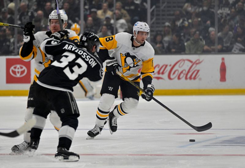 Feb 11, 2023; Los Angeles, California, USA;  ittsburgh Penguins defenseman Brian Dumoulin (8) skates the puck down ice as left wing Brock McGinn (23) blocks Los Angeles Kings right wing Viktor Arvidsson (33) in the first period at Crypto.com Arena. Mandatory Credit: Jayne Kamin-Oncea-USA TODAY Sports