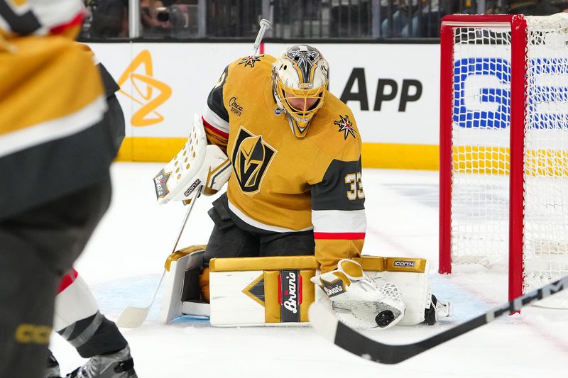 Apr 20, 2025; Las Vegas, Nevada, USA; Vegas Golden Knights goaltender Adin Hill (33) makes a glove save against the Minnesota Wild during the first period of game one of the first round of the 2025 Stanley Cup Playoffs at T-Mobile Arena. Mandatory Credit: Stephen R. Sylvanie-Imagn Images