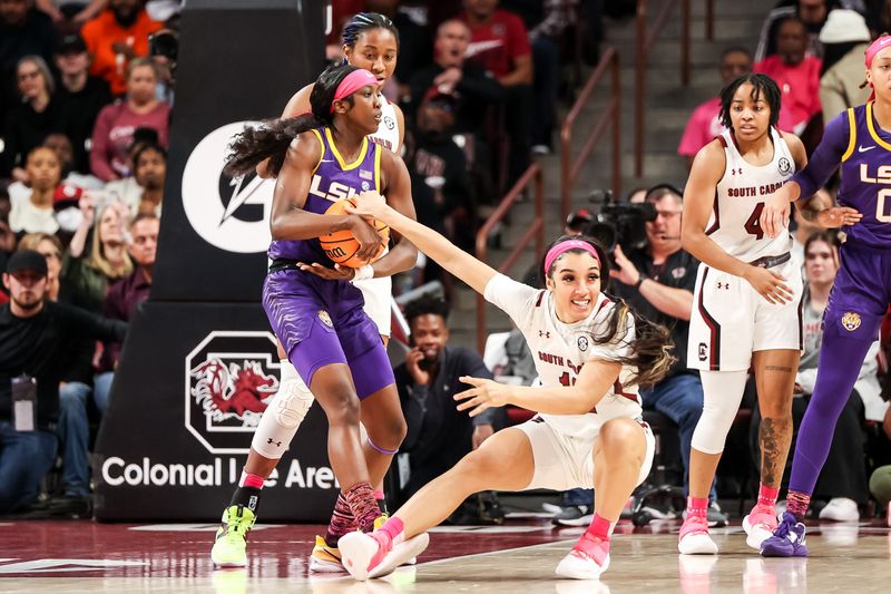 Feb 12, 2023; Columbia, South Carolina, USA; South Carolina Gamecocks guard Brea Beal (12) ties up LSU Lady Tigers guard Flau'jae Johnson (4) for a jump ball in the first half at Colonial Life Arena. Mandatory Credit: Jeff Blake-USA TODAY Sports