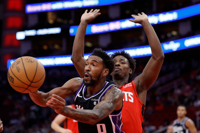 HOUSTON, TEXAS - NOVEMBER 06: Malik Monk #0 of the Sacramento Kings passes the ball ahead of Jae'Sean Tate #8 of the Houston Rockets during the first half at Toyota Center on November 06, 2023 in Houston, Texas. (Photo by Carmen Mandato/Getty Images)