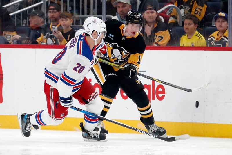 Oct 9, 2024; Pittsburgh, Pennsylvania, USA;  Pittsburgh Penguins left wing Drew O'Connor (10) moves the puck up ice against New York Rangers left wing Chris Kreider (20) during the first period at PPG Paints Arena. Mandatory Credit: Charles LeClaire-Imagn Images