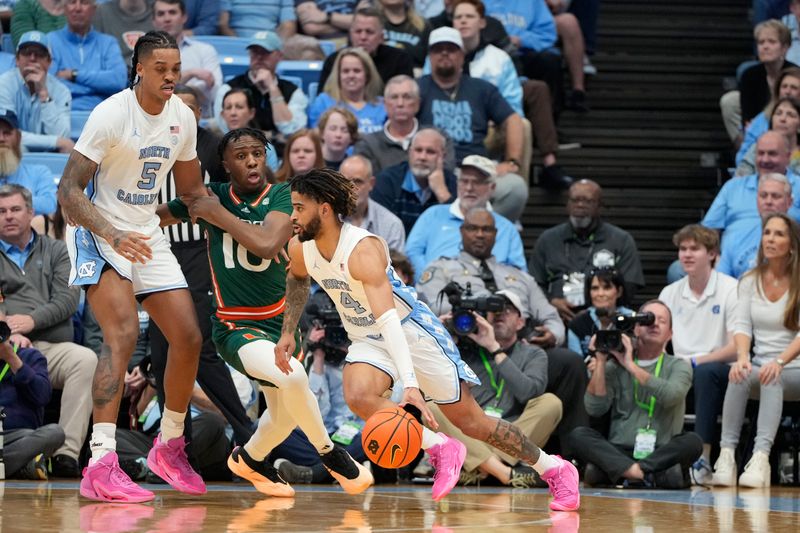 Feb 26, 2024; Chapel Hill, North Carolina, USA; North Carolina Tar Heels guard RJ Davis (4) with the ball as Miami (Fl) Hurricanes guard Paul Djobet (10) defends in the first half at Dean E. Smith Center. Mandatory Credit: Bob Donnan-USA TODAY Sports