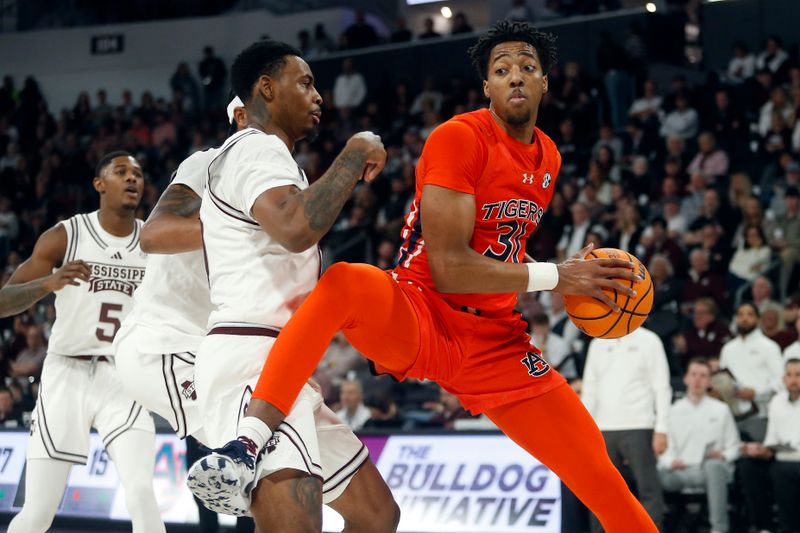 Jan 27, 2024; Starkville, Mississippi, USA; Auburn Tigers forward Chaney Johnson (31) collects a rebound over Mississippi State Bulldogs forward D.J. Jeffries (0) during the second half at Humphrey Coliseum. Mandatory Credit: Petre Thomas-USA TODAY Sports