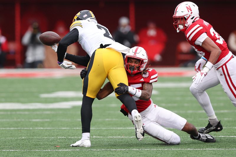 Nov 24, 2023; Lincoln, Nebraska, USA; Nebraska Cornhuskers defensive back Tamon Lynum (15) forces a fumble on Iowa Hawkeyes running back Kaleb Johnson (2) at Memorial Stadium. Mandatory Credit: Reese Strickland-USA TODAY Sports