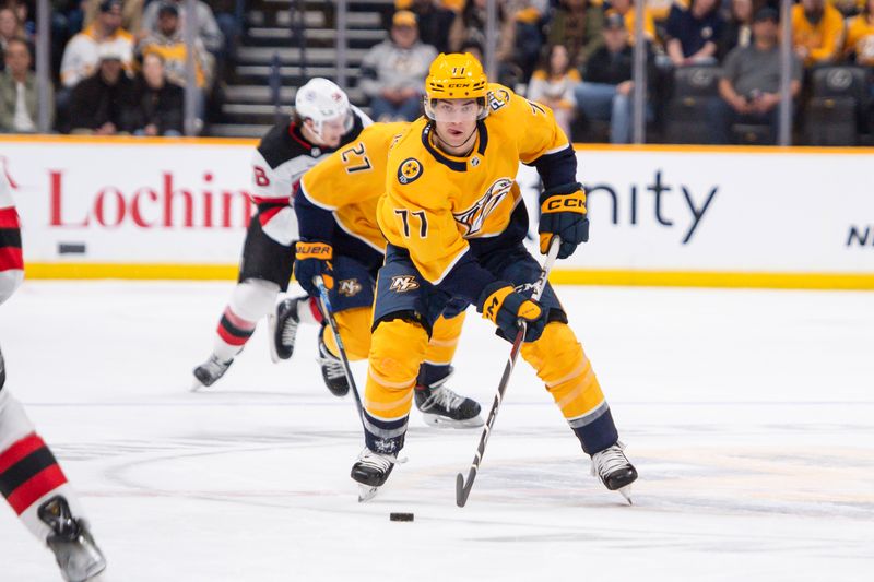 Feb 13, 2024; Nashville, Tennessee, USA;  Nashville Predators right wing Luke Evangelista (77) skates with the puck against the New Jersey Devils during the first period at Bridgestone Arena. Mandatory Credit: Steve Roberts-USA TODAY Sports