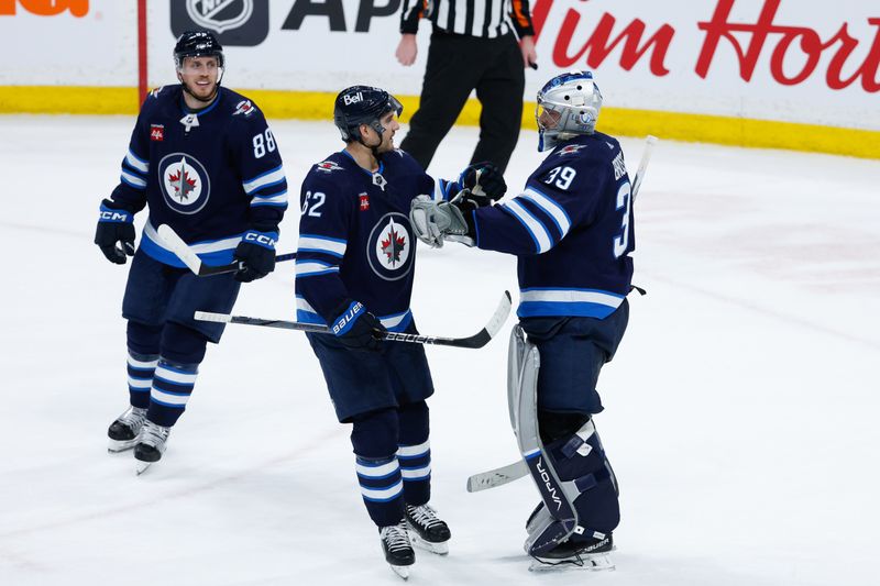 Mar 15, 2024; Winnipeg, Manitoba, CAN; Winnipeg Jets goalie Laurent Boissoit (39) is congratulated by Winnipeg Jets forward Nino Niederreiter (62) on his win against the Anaheim Ducks at the end of the third period at Canada Life Centre. Mandatory Credit: Terrence Lee-USA TODAY Sports