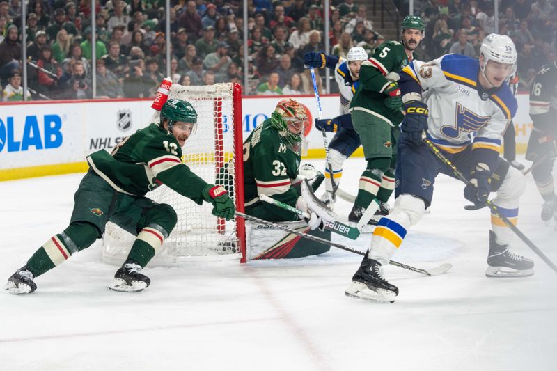 Apr 8, 2023; Saint Paul, Minnesota, USA; Minnesota Wild goaltender Filip Gustavsson (32) eyes the puck as Minnesota Wild center Sam Steel (13) engages St. Louis Blues right wing Alexey Toropchenko (13) in the first period at Xcel Energy Center. Mandatory Credit: Matt Blewett-USA TODAY Sports