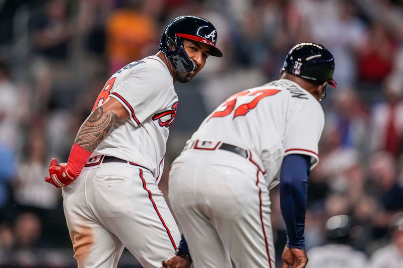 Apr 12, 2023; Cumberland, Georgia, USA; Atlanta Braves left fielder Eddie Rosario (8) reacts with third base coach Ron Washington (37) after hitting a home run against the Cincinnati Reds during the eighth inning at Truist Park. Mandatory Credit: Dale Zanine-USA TODAY Sports