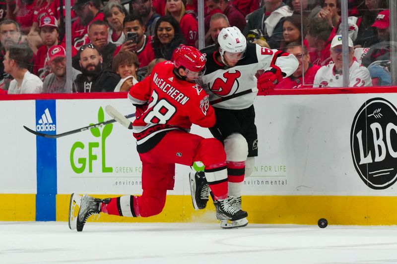 May 11, 2023; Raleigh, North Carolina, USA; New Jersey Devils defenseman John Marino (6) and Carolina Hurricanes left wing Mackenzie MacEachern (28) battle over the puck during the first period in game five of the second round of the 2023 Stanley Cup Playoffs at PNC Arena. Mandatory Credit: James Guillory-USA TODAY Sports