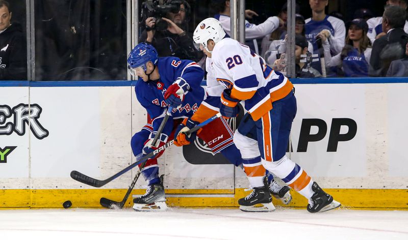 Sep 24, 2024; New York, New York, USA; New York Rangers defenseman Chad Ruhwedel (5) and New York Islanders right wing Hudson Fasching (20) fight for the puck along the boards during the second period at Madison Square Garden. Mandatory Credit: Danny Wild-Imagn Images