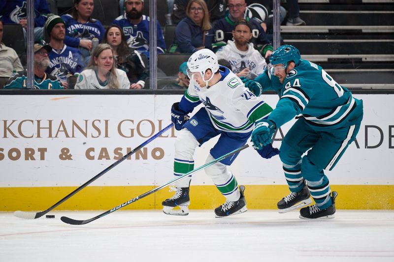 Nov 2, 2024; San Jose, California, USA; Vancouver Canucks center Pius Suter (24) controls the puck against San Jose Sharks defenseman Jan Rutta (84) during the third period at SAP Center at San Jose. Mandatory Credit: Robert Edwards-Imagn Images