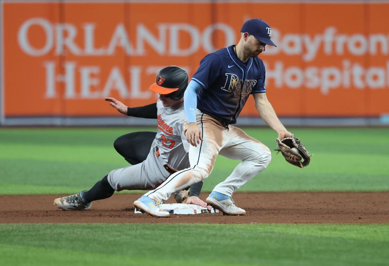 Jun 10, 2024; St. Petersburg, Florida, USA; Baltimore Orioles catcher James McCann (27) steals second base as Tampa Bay Rays second base Brandon Lowe (8) attempted to tag him out during the ninth inning at Tropicana Field. Mandatory Credit: Kim Klement Neitzel-USA TODAY Sports