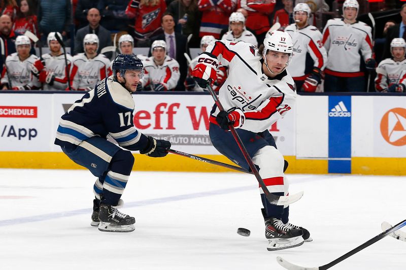 Dec 21, 2023; Columbus, Ohio, USA; Washington Capitals center Dylan Strome (17) passes the puck as Columbus Blue Jackets right wing Justin Danforth (17) trails the play during overtime at Nationwide Arena. Mandatory Credit: Russell LaBounty-USA TODAY Sports