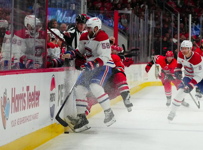 Dec 28, 2023; Raleigh, North Carolina, USA; Montreal Canadiens defenseman David Savard (58) checks Carolina Hurricanes right wing Jesper Fast (71) during the third period at PNC Arena. Mandatory Credit: James Guillory-USA TODAY Sports