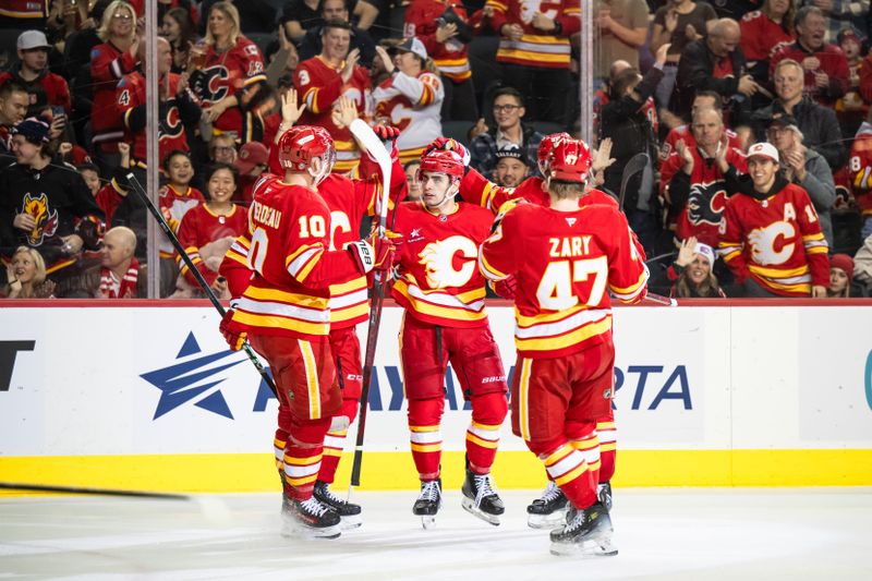 Dec 5, 2024; Calgary, Alberta, CAN; Calgary Flames right wing Matt Coronato (27) celebrates with Calgary Flames center Jonathan Huberdeau (10), center Connor Zary (47) and teammates after scoring a goal against the St. Louis Blues during the second period at Scotiabank Saddledome. Mandatory Credit: Brett Holmes-Imagn Images