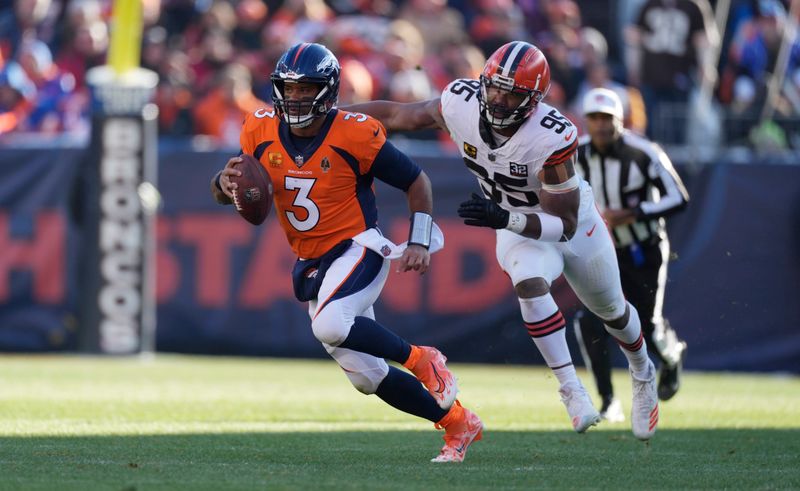 Denver Broncos quarterback Russell Wilson (3) is pursued by Cleveland Browns defensive end Myles Garrett (95) in the first half of an NFL football game Sunday, Nov. 26, 2023, in Denver. (AP Photo/David Zalubowski)