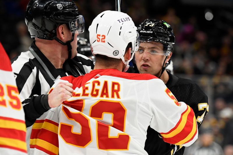 Feb 6, 2024; Boston, Massachusetts, USA; Boston Bruins defenseman Charlie McAvoy (73) has words with Calgary Flames defenseman MacKenzie Weegar (52) during the third period at TD Garden. Mandatory Credit: Bob DeChiara-USA TODAY Sports