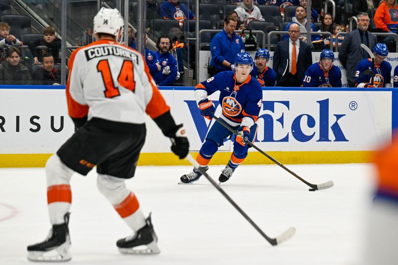 Nov 28, 2025; Elmont, New York, USA; New York Islanders defenseman Matthew Schaefer (48) controls the puck defended by Philadelphia Flyers center Sean Couturier (14) during the second period at UBS Arena. Mandatory Credit: Dennis Schneidler-Imagn Images