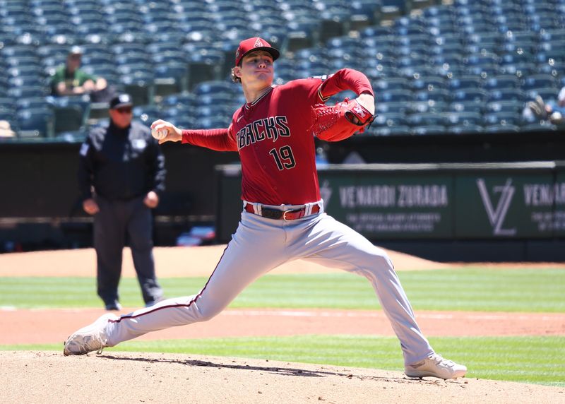 May 17, 2023; Oakland, California, USA; Arizona Diamondbacks starting pitcher Ryne Nelson (19) pitches the ball against the Oakland Athletics during the first inning at Oakland-Alameda County Coliseum. Mandatory Credit: Kelley L Cox-USA TODAY Sports