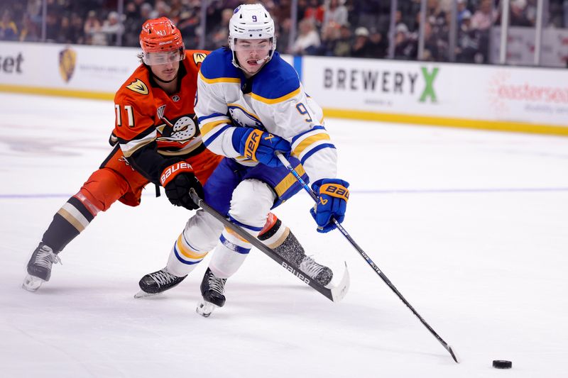 Nov 22, 2024; Anaheim, California, USA; Buffalo Sabres left wing Zach Benson (9) controls the puck ahead of Anaheim Ducks center Trevor Zegras (11) during the third period at Honda Center. Mandatory Credit: Ryan Sun-Imagn Images