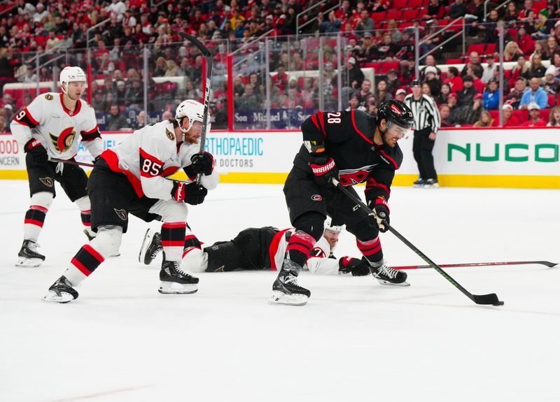 Nov 16, 2024; Raleigh, North Carolina, USA;  Carolina Hurricanes left wing William Carrier (28) scores. An empty net goal past Ottawa Senators defenseman Thomas Chabot (72) and defenseman Jake Sanderson (85) during the third period at Lenovo Center. Mandatory Credit: James Guillory-Imagn Images