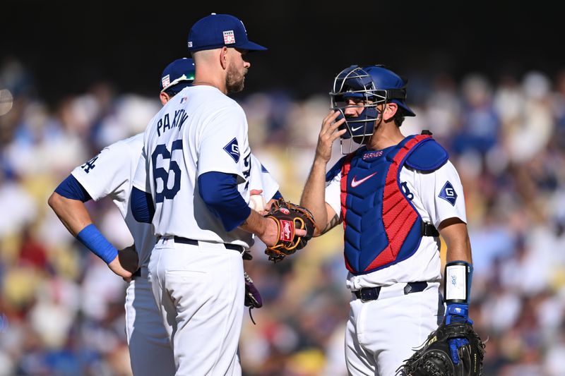 Jul 21, 2024; Los Angeles, California, USA; Los Angeles Dodgers catcher Austin Barnes (15) and pitcher James Paxton (65) meet at the mound during the sixth inning at Dodger Stadium. Mandatory Credit: Jonathan Hui-USA TODAY Sports