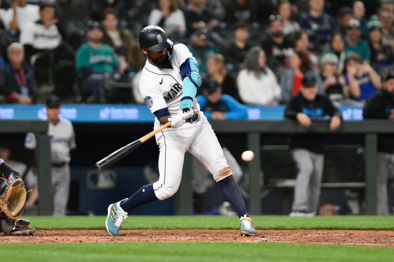 Jun 14, 2023; Seattle, Washington, USA; Seattle Mariners right fielder Teoscar Hernandez (35) hits a single against the Miami Marlins during the ninth inning at T-Mobile Park. Mandatory Credit: Steven Bisig-USA TODAY Sports