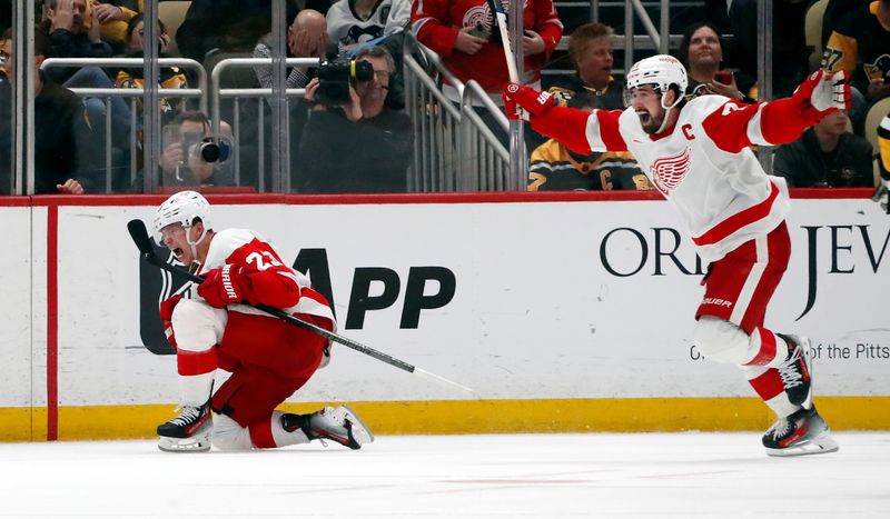 Apr 11, 2024; Pittsburgh, Pennsylvania, USA; Detroit Red Wings left wing Lucas Raymond (23) and center Dylan Larkin (71) celebrate after Raymond scored a goal to complete a hat-trick against the Pittsburgh Penguins during the third period at PPG Paints Arena. Pittsburgh won 6-5 in overtime. Mandatory Credit: Charles LeClaire-USA TODAY Sports