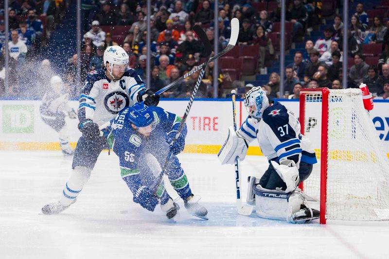 Feb 17, 2024; Vancouver, British Columbia, CAN; Winnipeg Jets forward Adam Lowry (17) cehcks Vancouver Canucks forward Teddy Blueger (53) as goalie Connor Hellebuyck (37) watches the rebound in the second period at Rogers Arena. Mandatory Credit: Bob Frid-USA TODAY Sports