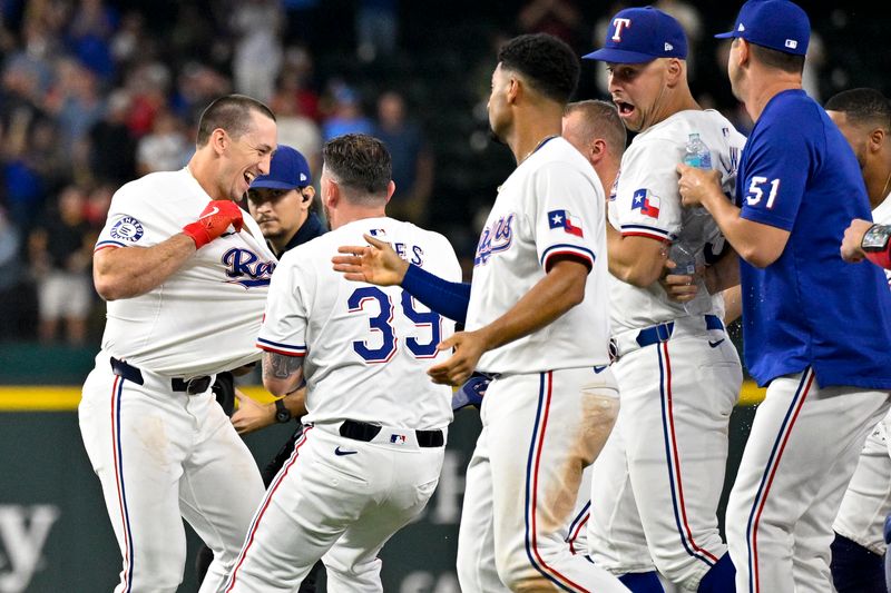 Aug 21, 2024; Arlington, Texas, USA; Texas Rangers left fielder Wyatt Langford (36) and relief pitcher Kirby Yates (39) and second baseman Marcus Semien (2) and first baseman Nathaniel Lowe (30) celebrate after Langford drives in the game winning run by pinch runner Ezequiel Duran (not pictured) against the Pittsburgh Pirates during the ninth inning at Globe Life Field. Mandatory Credit: Jerome Miron-USA TODAY Sports