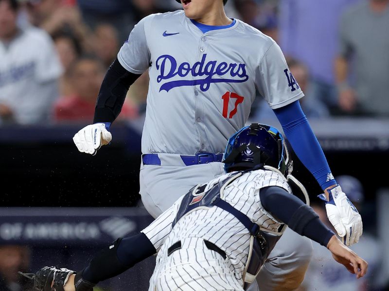 Jun 9, 2024; Bronx, New York, USA; Los Angeles Dodgers designated hitter Shohei Ohtani (17) scores ahead of the tag by New York Yankees catcher Jose Trevino (39) on a sacrifice fly by Dodgers catcher Will Smith (not pictured) during the eighth inning at Yankee Stadium. Mandatory Credit: Brad Penner-USA TODAY Sports