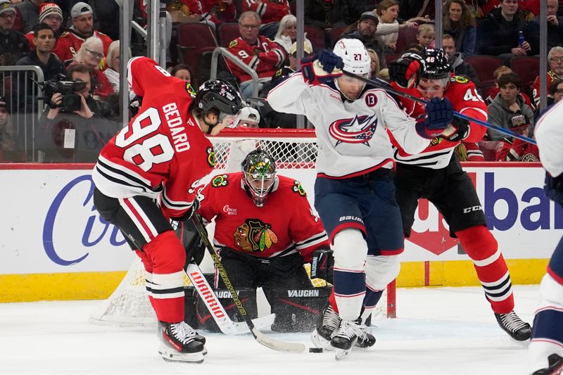 Dec 1, 2024; Chicago, Illinois, USA; Chicago Blackhawks center Connor Bedard (98) and Columbus Blue Jackets center Zachary Aston-Reese (27) go for the puck during the second period at United Center. Mandatory Credit: David Banks-Imagn Images