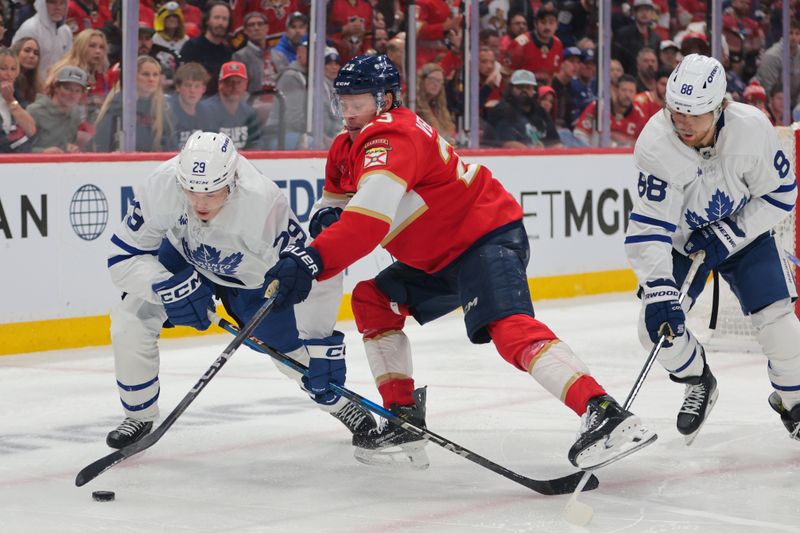 May 9, 2025; Sunrise, Florida, USA; Florida Panthers center Carter Verhaeghe (23) and Toronto Maple Leafs right wing Pontus Holmberg (29) battle for the puck during overtime in game three of the second round of the 2025 Stanley Cup Playoffs at Amerant Bank Arena. Mandatory Credit: Sam Navarro-Imagn Images