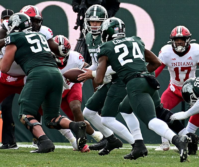 Nov 19, 2022; East Lansing, Michigan, USA;  Michigan State Spartans quarterback Payton Thorne (10) hands the ball to running back Elijah Collins (24) for a touchdown against the Indiana Hoosiers at Spartan Stadium. Mandatory Credit: Dale Young-USA TODAY Sports