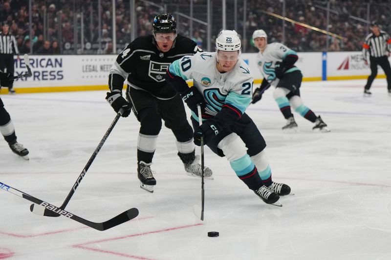 Dec 20, 2023; Los Angeles, California, USA; Seattle Kraken right wing Eeli Tolvanen (20) and LA Kings defenseman Mikey Anderson (44) battle for the puck in the first period at Crypto.com Arena. Mandatory Credit: Kirby Lee-USA TODAY Sports